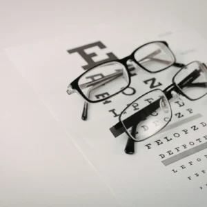An eye chart with two pairs of black frame glasses on top